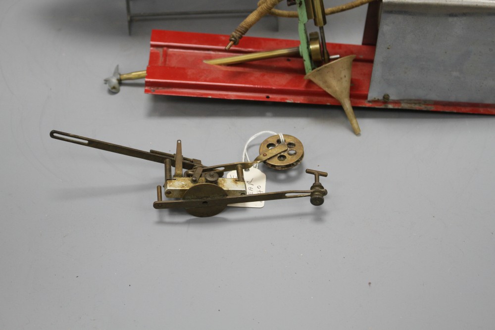 A 1950s Mamod ME1 clockwork steam engine, a Vane gear for a pond yacht and a modern painted metal model of a boat